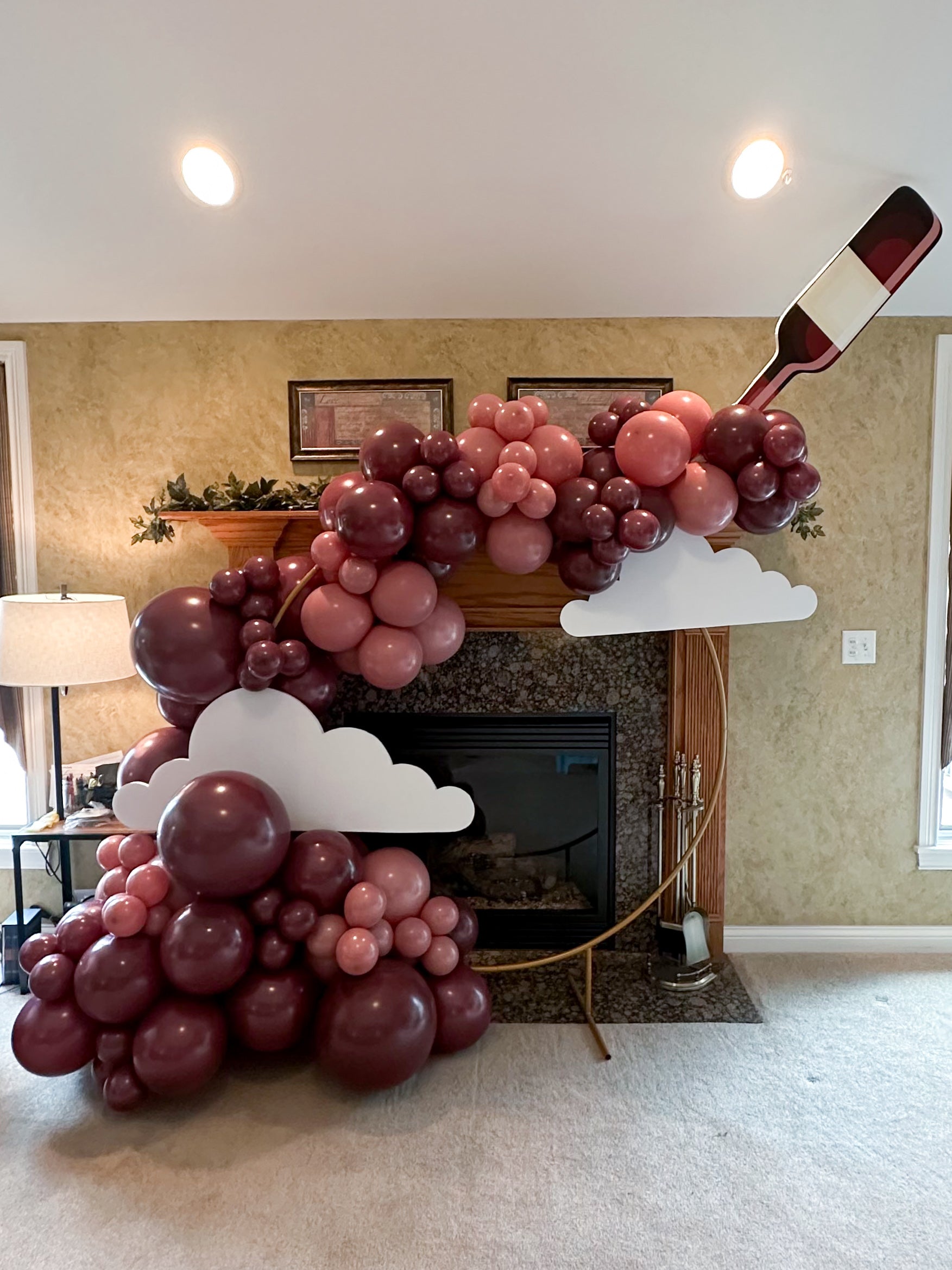 Balloon arch with wine bottle and clouds.